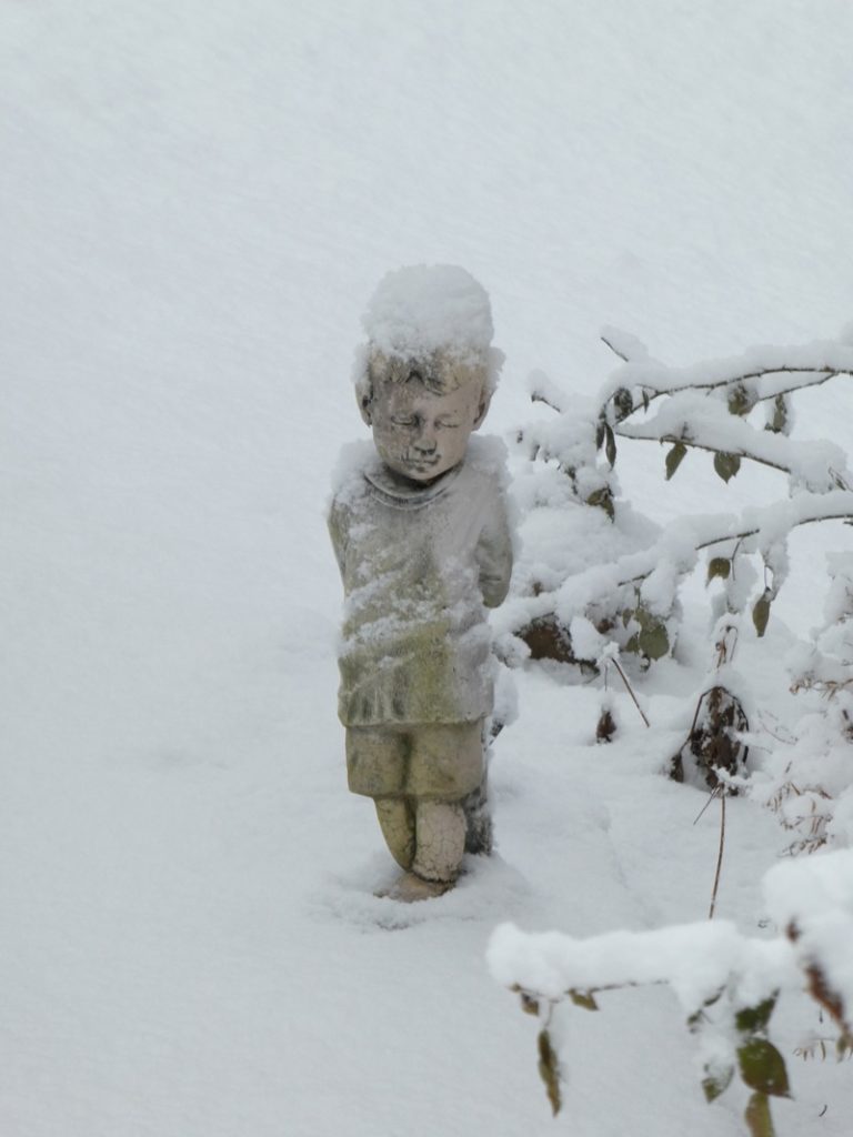 Statue of boy in snow